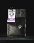 Black coffee bag with a label on a black background