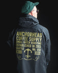 Person wearing a dark jacket with Anchorhead Coffee Supply branding on the back against a black background