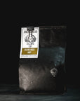 Black coffee bag with a label on a dark background
