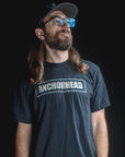 Man wearing a black t-shirt with 'Anchorhead' logo against a dark background