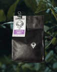 Black coffee bag with a label on a black background